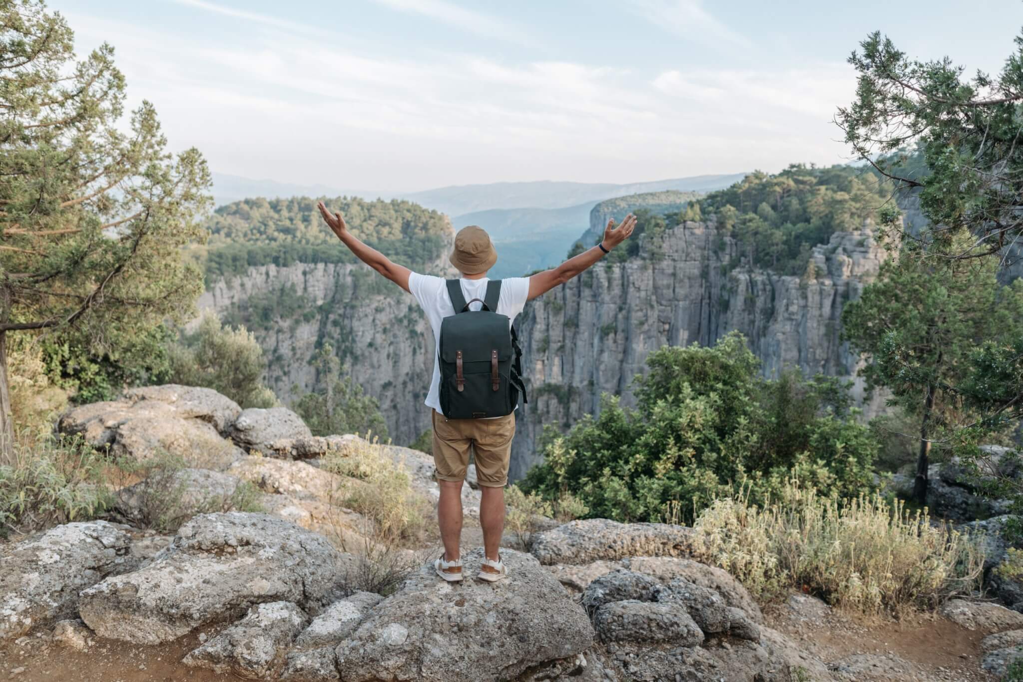 Man wearing a backpack while hiking on a mountain