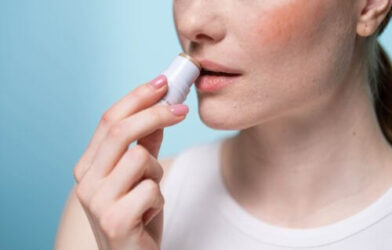 Woman applying lip balm to her lips