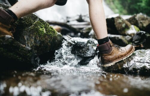 someone walking through a stream in hiking boots