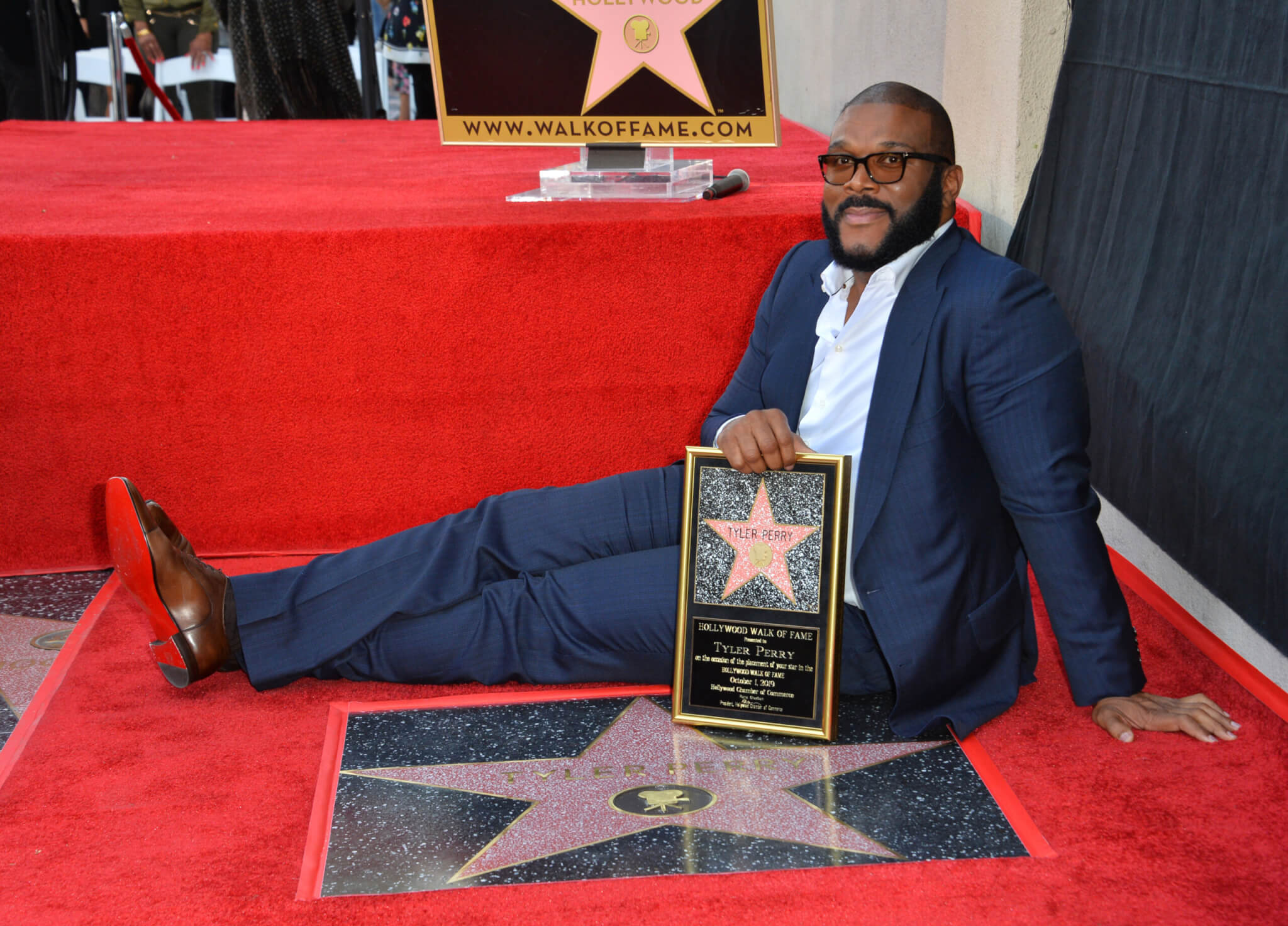 Tyler Perry posing with his star on the Hollywood Walk of Fame