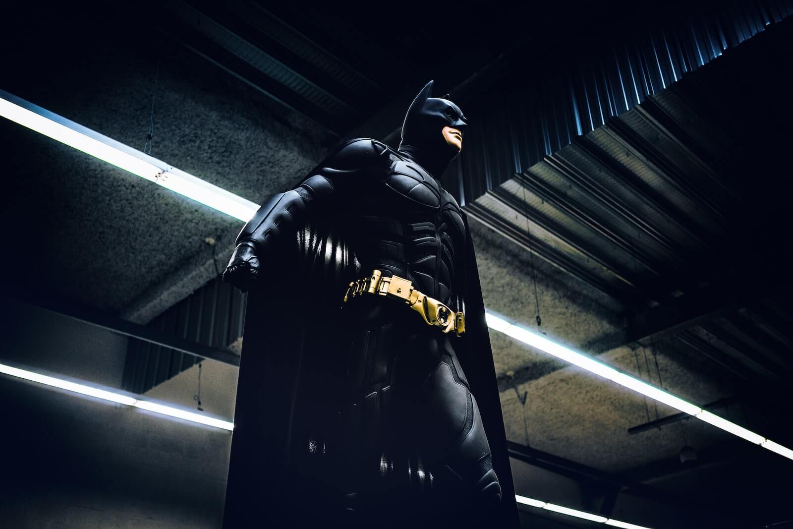 Batman standing under steel roof and lights